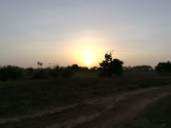 Scenic view of silhouette field against sky at sunset