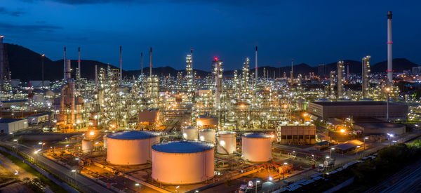 Aerial view oil and gas tank with oil refinery background at night, glitter lighting petrochemical.