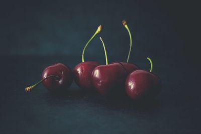 Close-up of cherries on table against black background