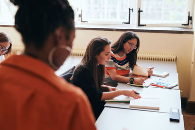 Female students writing in books in language school