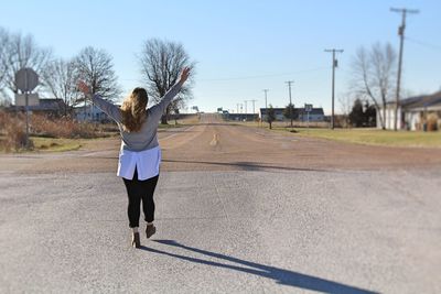 Rear view of woman walking on road