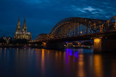 Illuminated bridge over river at night