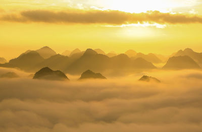 Scenic view of dramatic sky over mountains during sunset