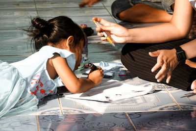 Midsection of woman holding paper while sitting on table