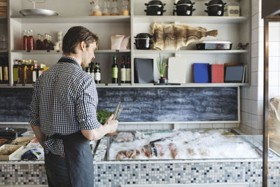 Male owner standing by retail display at fish store