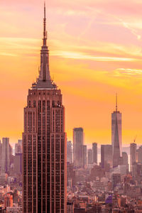 Empire state building against sky during sunset