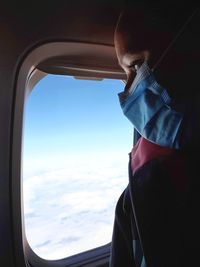 Portrait of person looking through airplane window