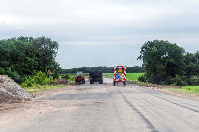 Vehicles on road against sky