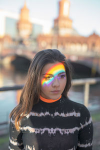 Portrait of woman standing against multi colored city