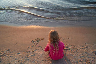 High angle view of girl sitting on beach