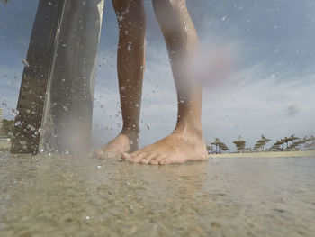Low section of man swimming in sea