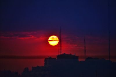 Low angle view of illuminated building against sky at sunset