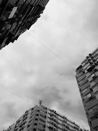 Low angle view of buildings against cloudy sky