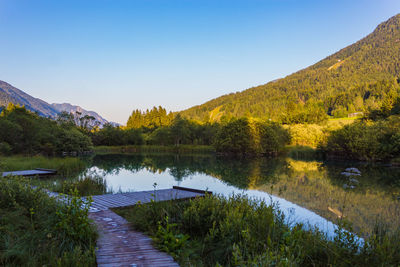 Scenic view of lake and mountains against clear sky