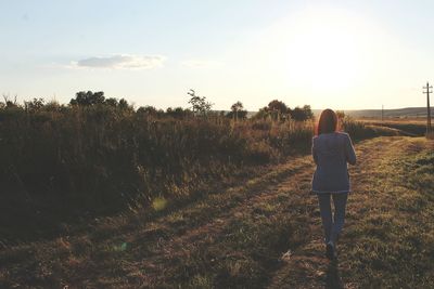 Rear view of woman standing on field