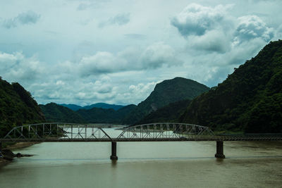 Bridge over river with mountains in background