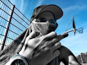 Low angle view of man wearing sunglasses against sky