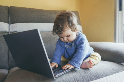 Girl sitting on sofa at home