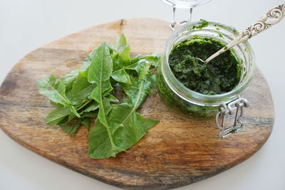 High angle view of dandelion pesto sauce on cutting board against gray background