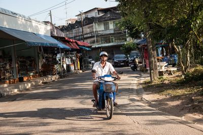 Woman riding bicycle on road in city