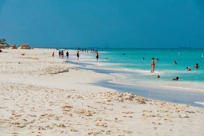 People at beach against sky