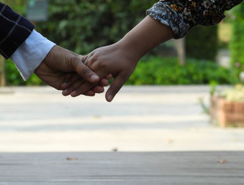 Midsection of man holding hands against sea