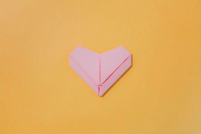 Close-up of heart shape on yellow background