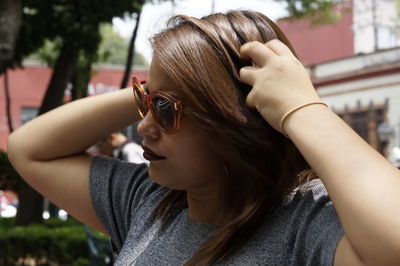 Close-up of woman with hands in hair