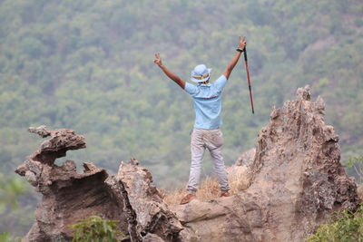 Rear view of man standing on rock