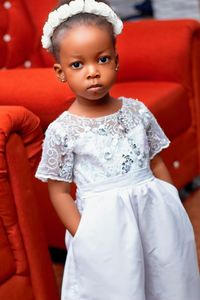 Portrait of cute girl sitting near sofa at home