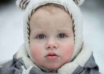 Close-up portrait of cute baby in snow