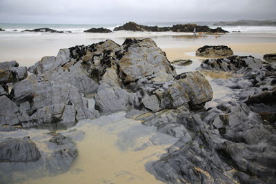 Rocks on beach against sky