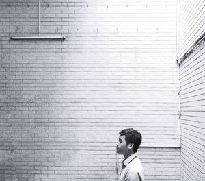 Portrait of young man standing against wall