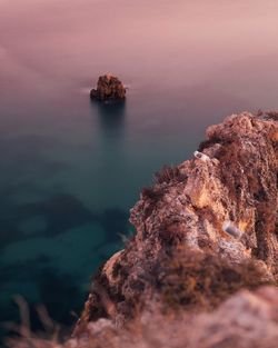 Rock formation in sea against sky