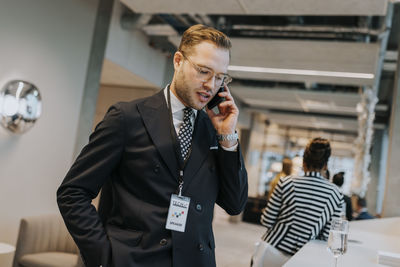 Young businessman talking on mobile phone during networking conference