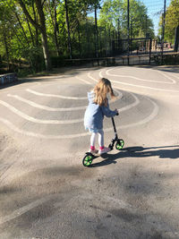 Girl riding bicycle on road in city