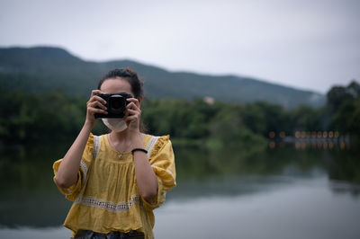 Series photo of young women wearing surgical protection mask playing with camera in the evening