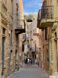 People walking on street amidst buildings in city