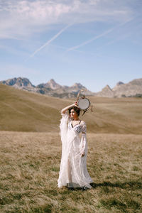 Woman standing on field against sky