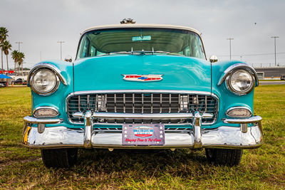 Vintage car on field against blue sky