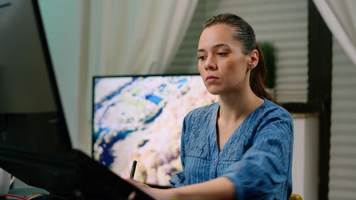 Portrait of young woman using laptop at home