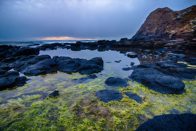 Rock formations in sea against sky