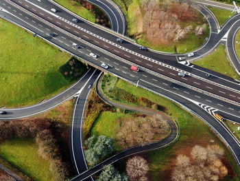 Aerial view from above on curvy road junctions and highway with cars