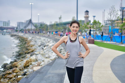 Portrait of smiling young woman standing in city