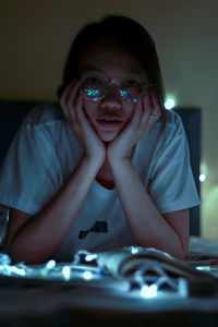 Young woman with illuminated string light at home