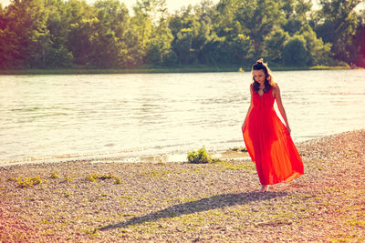 Woman looking down while walking at lakeshore