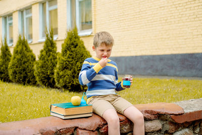 Boy eating food while sitting outdoors