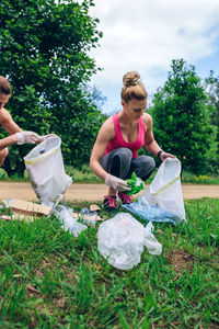 Female volunteers collecting garbage on field