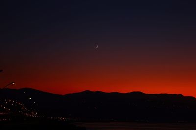 Scenic view of silhouette mountains against romantic sky at sunset