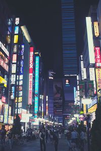 People walking in illuminated city at night